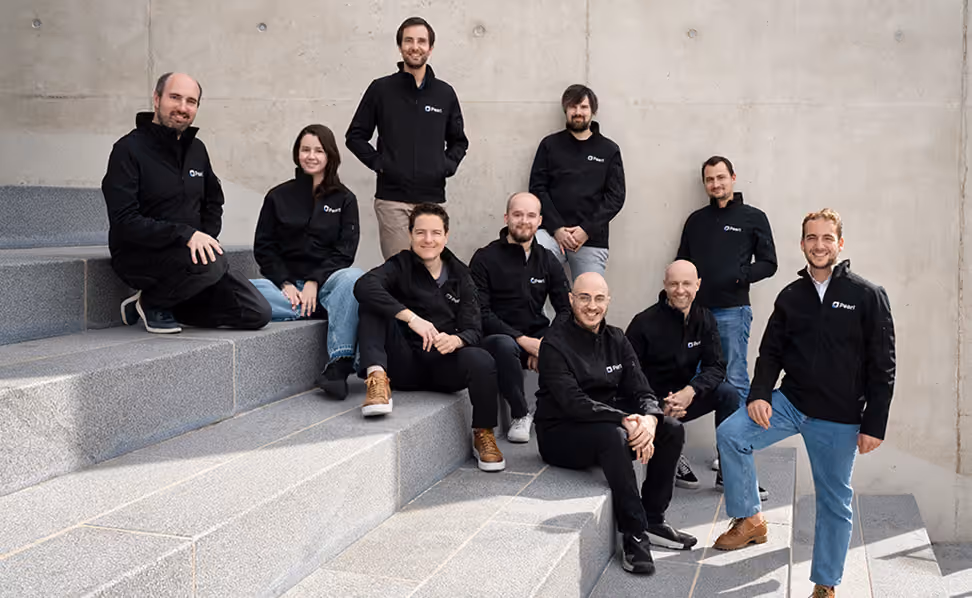 The Pearl team on concrete steps, in Pearl jackets